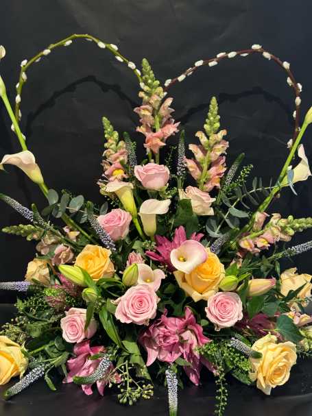 Vibrant floral arrangement featuring pink, yellow, and white flowers with green foliage.
