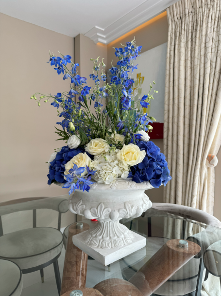 A floral arrangement featuring blue and white flowers in a decorative vase.