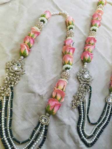 Ornate necklace featuring pink floral elements and intricate silver detailing.