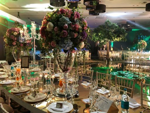 Elegant banquet setup with floral centrepieces and decorative lighting.