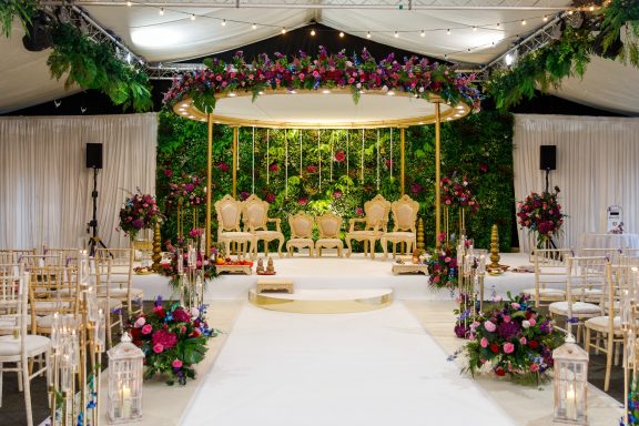 Elegant wedding setup with floral decorations, a circular arch, and arranged seating.