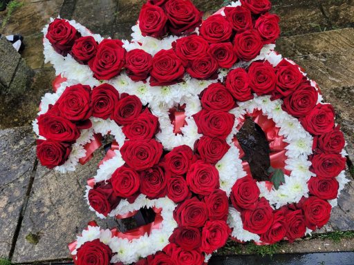 Red and white flower arrangement forming the symbol "Om".