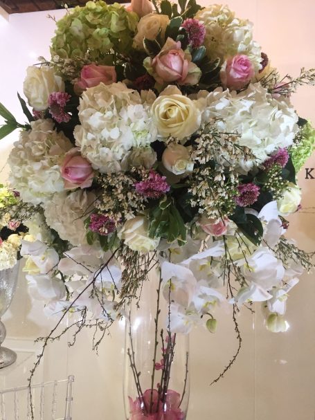 A bouquet of white and pink flowers with greenery, elegantly arranged.