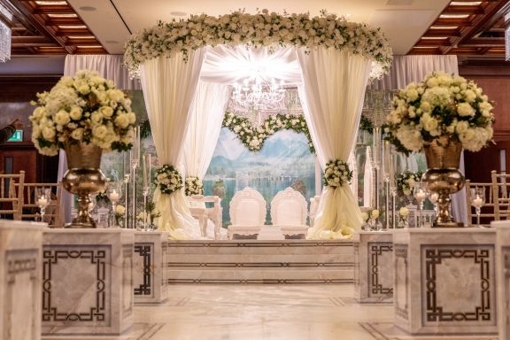 Elegant wedding altar adorned with flowers, drapes, and a scenic backdrop.