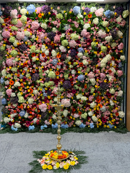 A vibrant wall of colourful flowers with a decorative stand at the base.